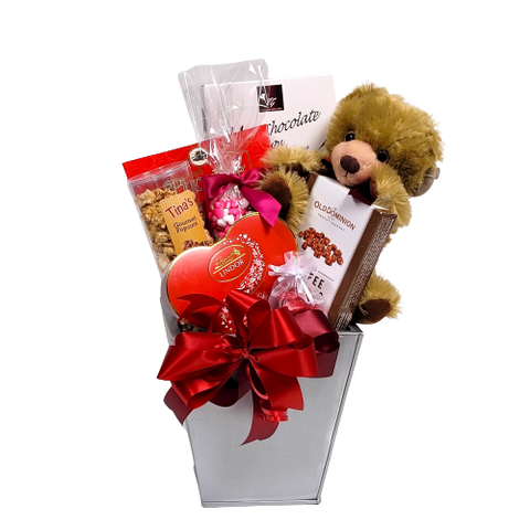 Nestled in this pretty tin is an assortment of chocolates, popcorn, nuts, cookies all adorned with a plush bear to add a touch of warmth.