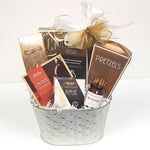 A beautiful white and gold tin gift basket filled with crackers and cheese, maple glazes smoked salmon, pretzels, red pepper jelly, cookies & chocolate too.