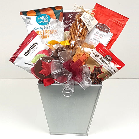 A pretty silver planter gift basket loaded with sweet potato chips, maple roasted cashews, Martin's apple chips, pretzels, chocolates, peanut brittle and more.