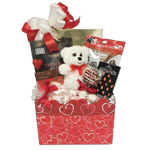 Carefully arranged among the delicious delicacies is a charming Valentine's Day teddy bear accompanied by gourmet popcorn, cookies, pretzels coated in chocolate, delectable truffles, assorted nuts and more.