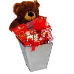 A cuddly plush bear delivers lots of snuggles and delicious treats with this gift basket. There's truffles, candies, cookies & more! It's a Beary-Licious gift basket to receive!