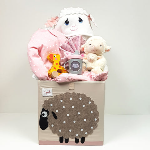 A baby gift basket with a trendy storage cube filled it with a sleeper, Precious Moments Hooded Towel, plush toy, receiving blanket, pull toy and sippy mug too!