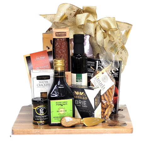 A beautiful cheese board and knife set holds a beautiful assortment of gourmet delights. There's specialty oil and vinegar, cheese, crackers, mustard, salmon, artisanal salami and of course some chocolate to enjoy.