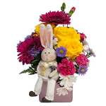 Designed in a pretty pink glass cube vase is a fresh assortment of bright blooms with a cute keepsake bunny nestled inside.  
