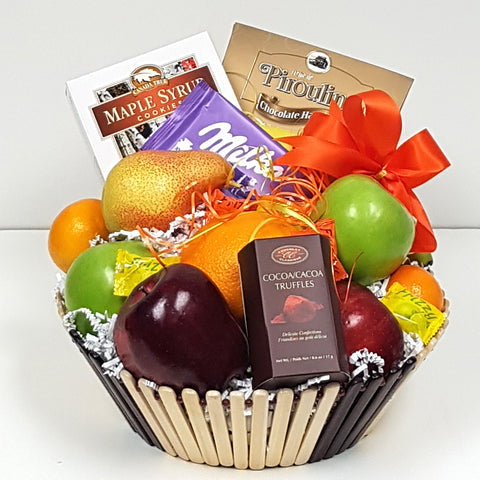 Nestled in an assortment of fruits there's a treasure of truffles, chocolates & yummy cookies in a fruit gift basket.