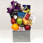 A  fruit gift basket holding a bountiful assortment of fruit, jam, cheese, crackers, nuts, chocolates and so much more.