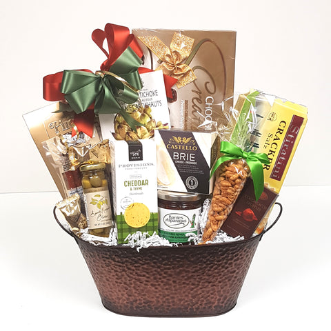 A gourmet gift basket with a chockful of chocolate, nuts, crackers, cheese, gourmet dip mix, nuts, red pepper jelly, savoury shortbread, pepperoni and more.