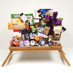 A breakfast tray gourmet gift basket overflowing with coffee, tea, pancake mix, handmade shortbread, jam, Royal Canadian wildflower honey, maple syrup, a pair of coffee mugs, sparkling apple cider and European chocolates to name a few.