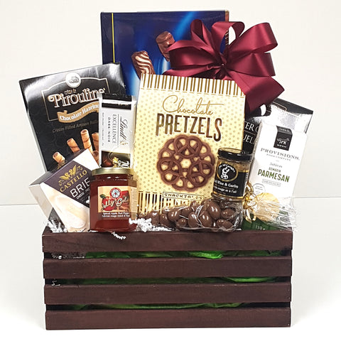 A crate gourmet gift basket loaded with chocolates, cookies, crackers, cheese, red pepper jelly, mustard and savoury shortbread too.