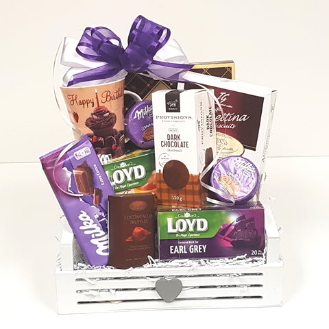 A pretty wood crate gift basket loaded with a birthday mug, cookies, chocolates and a variety of tea.