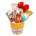 Popcorn bucket filled with lots of munchy snacks. There's nachos and salsa, nacho spice, pepperoni sticks, cheese, popcorn and seasoning, nuts and chocolate too.