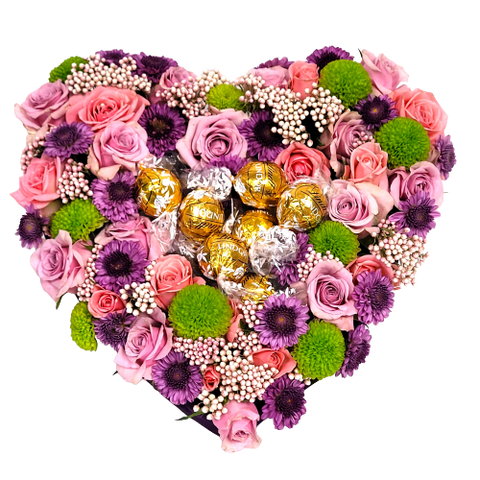 Solid heart pavé floral arrangement of roses and poms with Lindt truffles nestled in the centre. 
