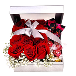 Nestled inside a silver sparkly box is a dozen red roses and truffles to enjoy.