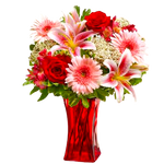 Tall red glass vase filled with red roses, pink gerberas, alstromeria, lilies, rice flowers and greens.