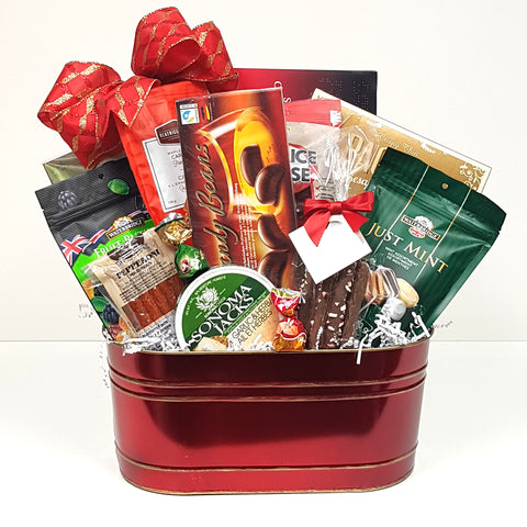 A  Christmas gift basket filled with a delicious assortment of sweets, cheese, crackers and pepperoni.